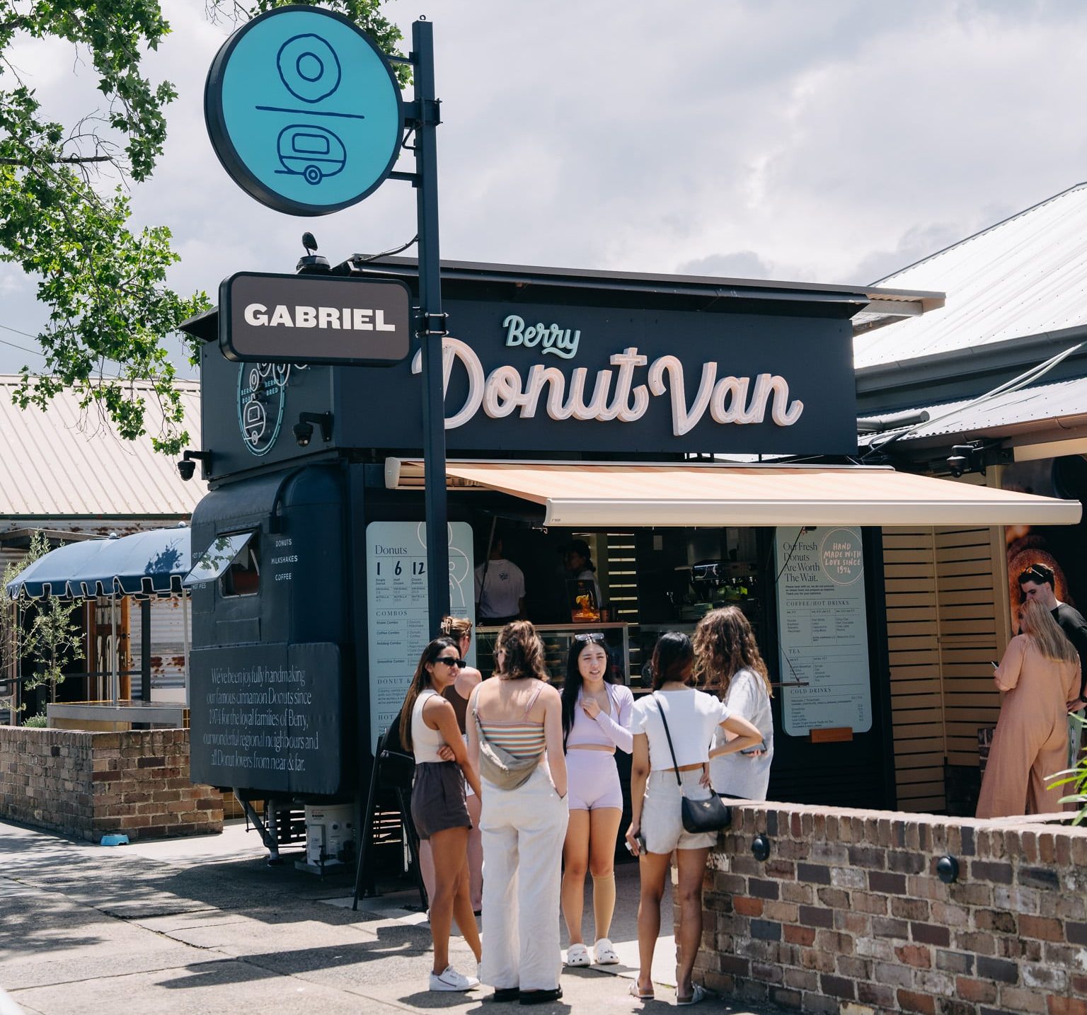 The Berry Donut Van counter and awning with the queue forming on a sunny day