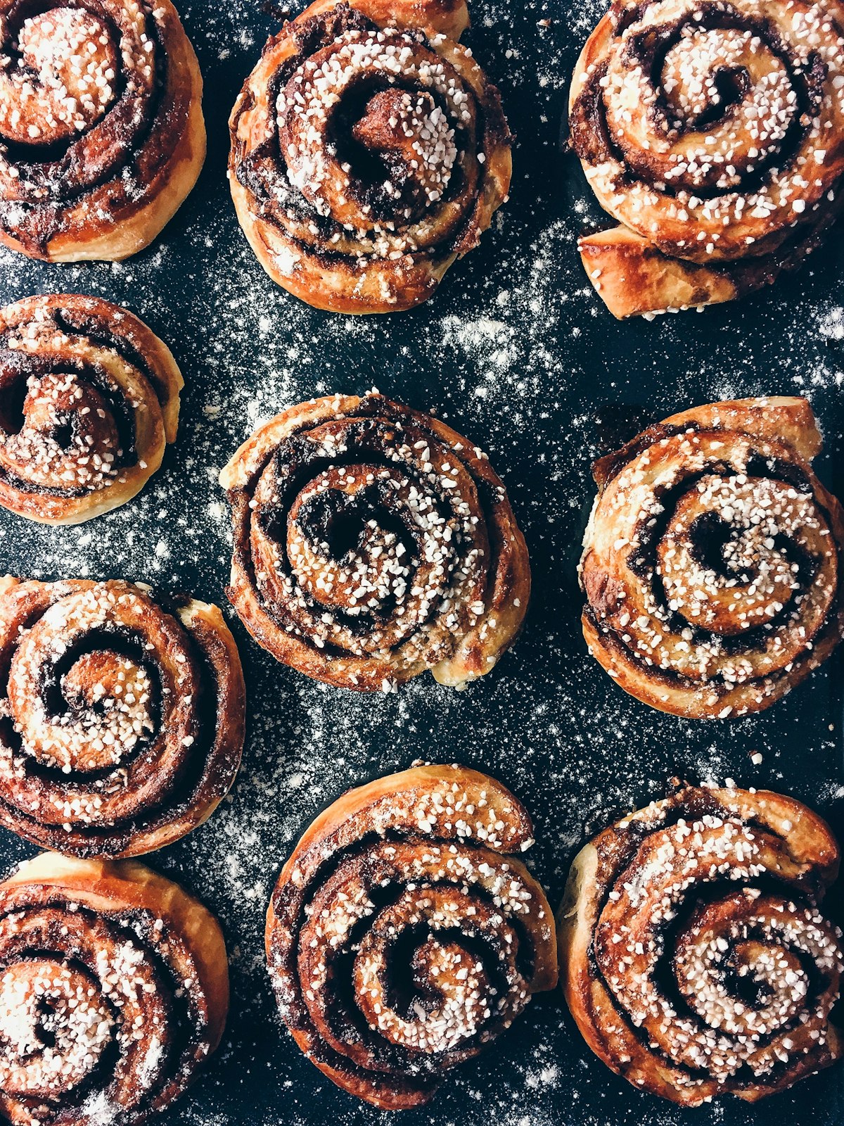 A tray of fresh cinnamon scrolls dusted with sugar