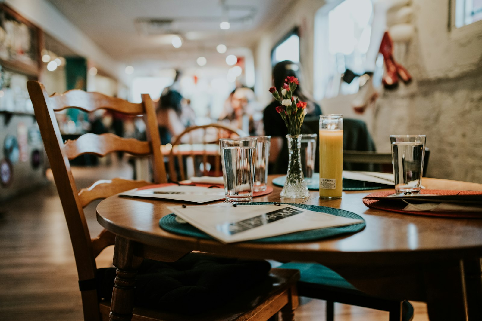 A round cafe table set with flowers and a candle