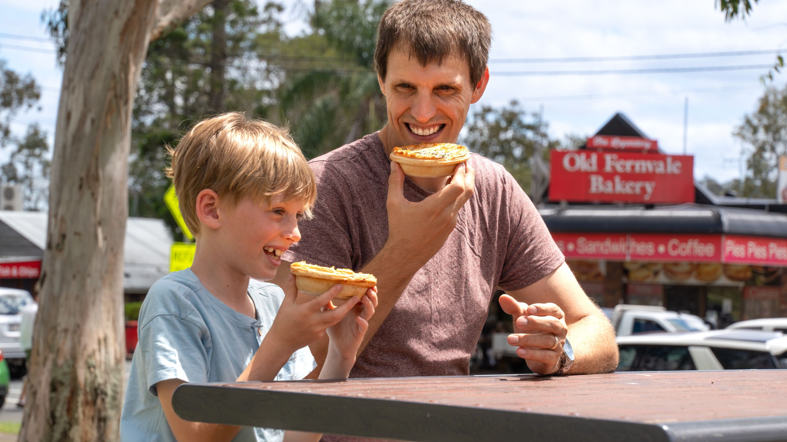 A father and son holding fresh Fernvale pies outside the Old Fernvale Bakery
