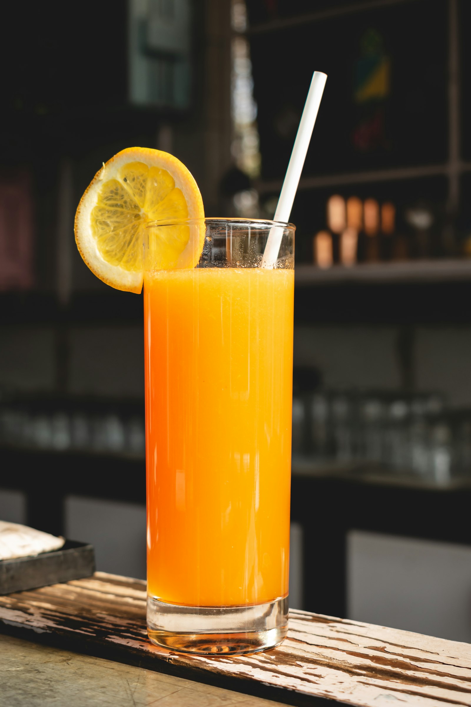 A tall glass of fresh orange juice with an orange slice