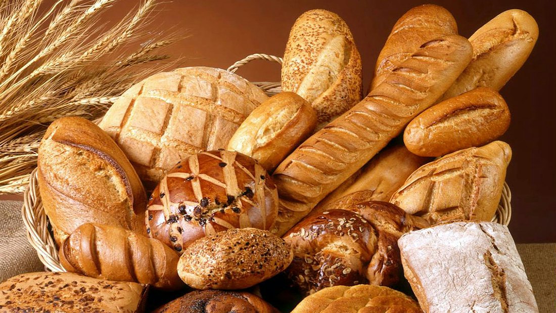 A basket piled high with fresh loaves, rolls and buns