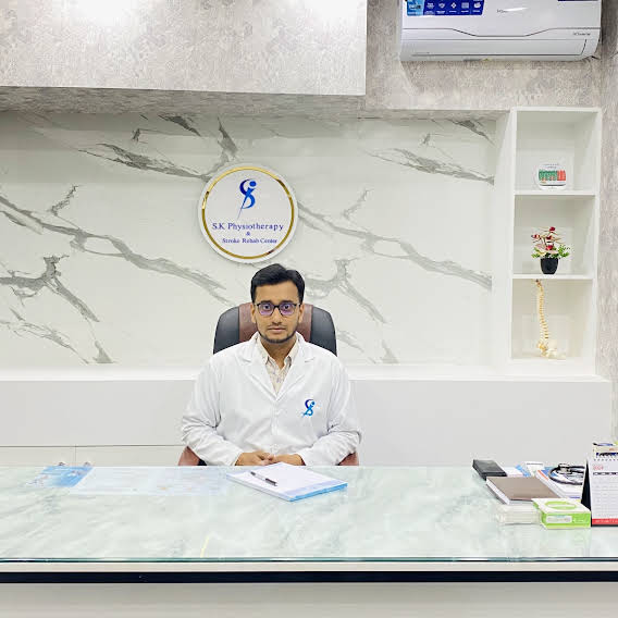 Inside S.K Physiotherapy & Stroke Rehab Center — the consultation room with the centre's sign on the wall